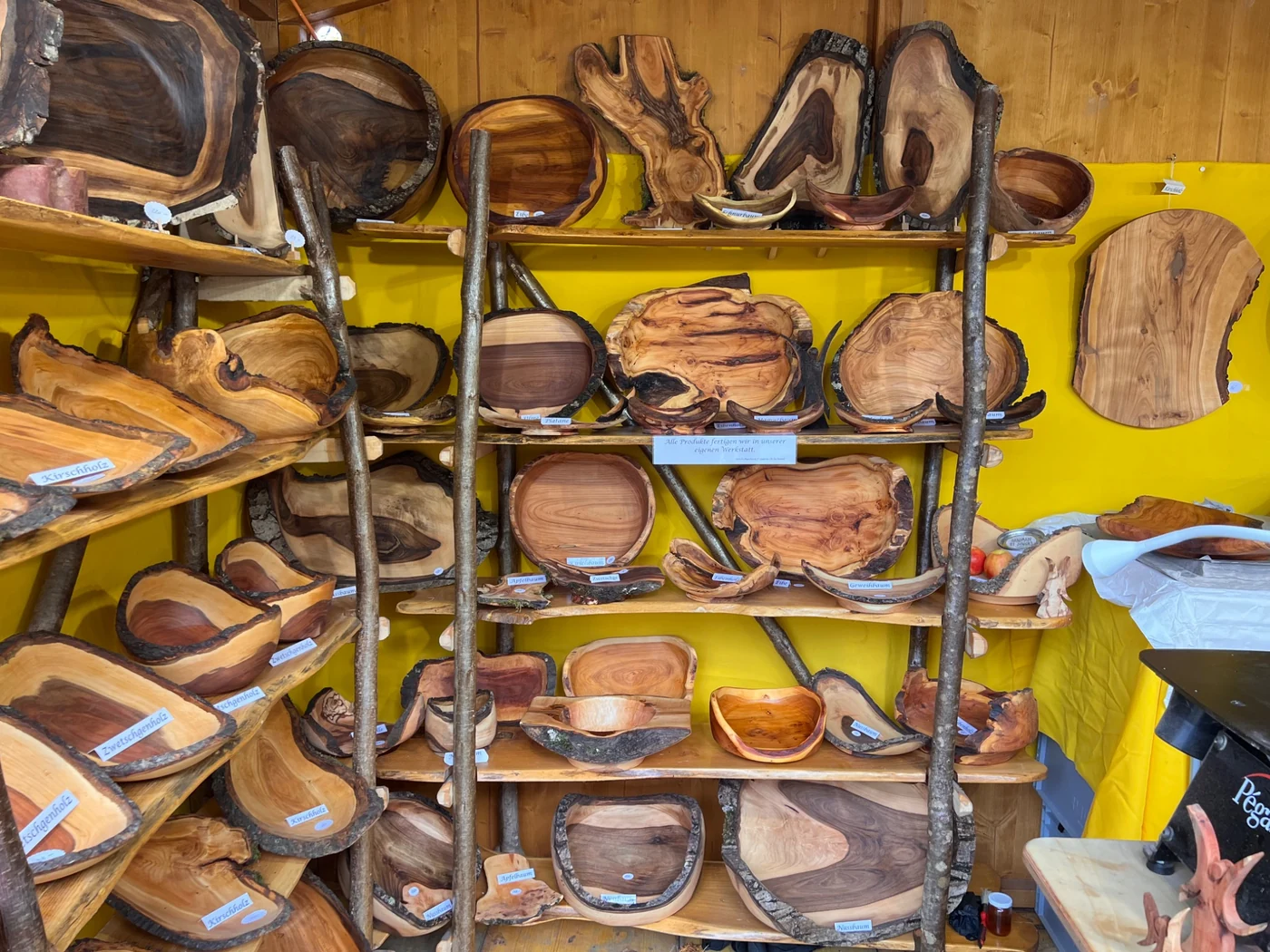 Verschiedene gedrechselte Holzschalen in den Regalen des Marktstands